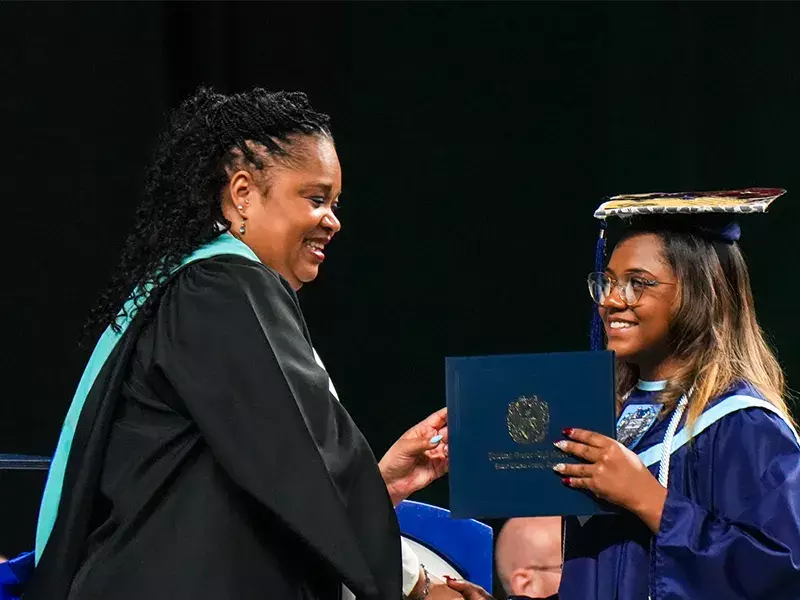 Student receiving her diploma during the class of 2026 graduation ceremony